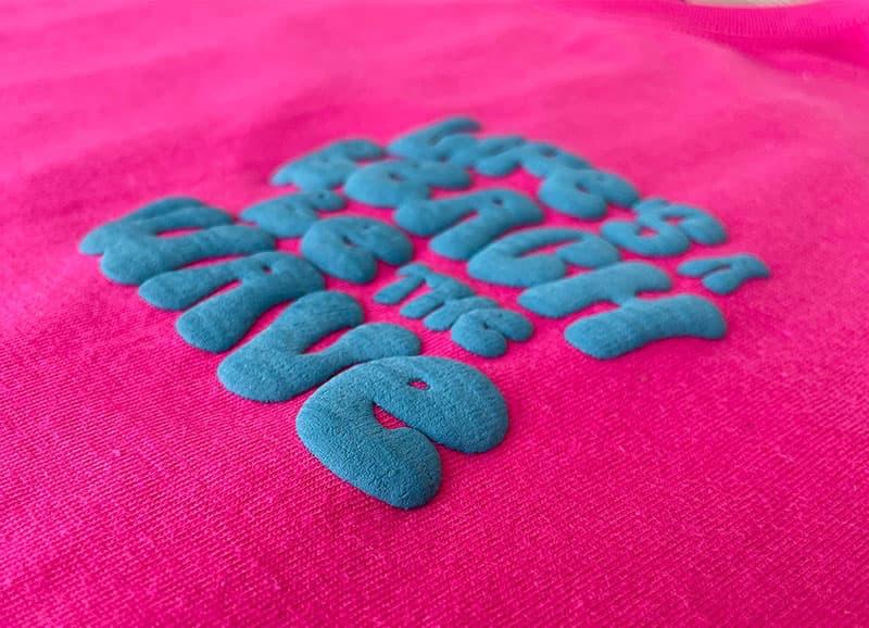Raised teal puff print on a pink Inkse tee
